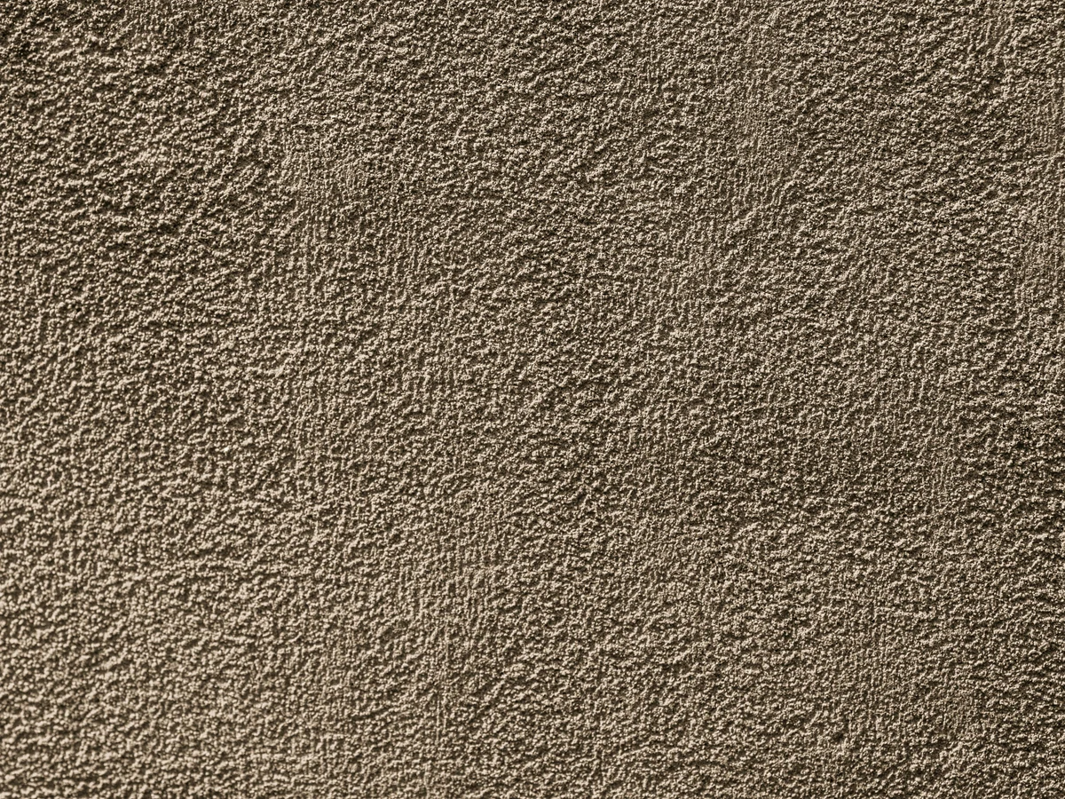 Close-up of rough textured masonry surface being painted in Darlington by Darlington Decorators
