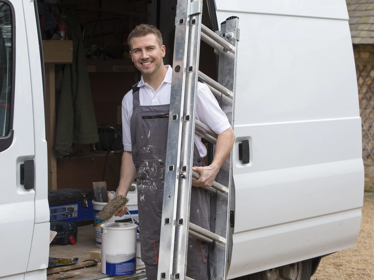 Smiling painter and decorator on a ladder in Catterick Village by Darlington Decorators