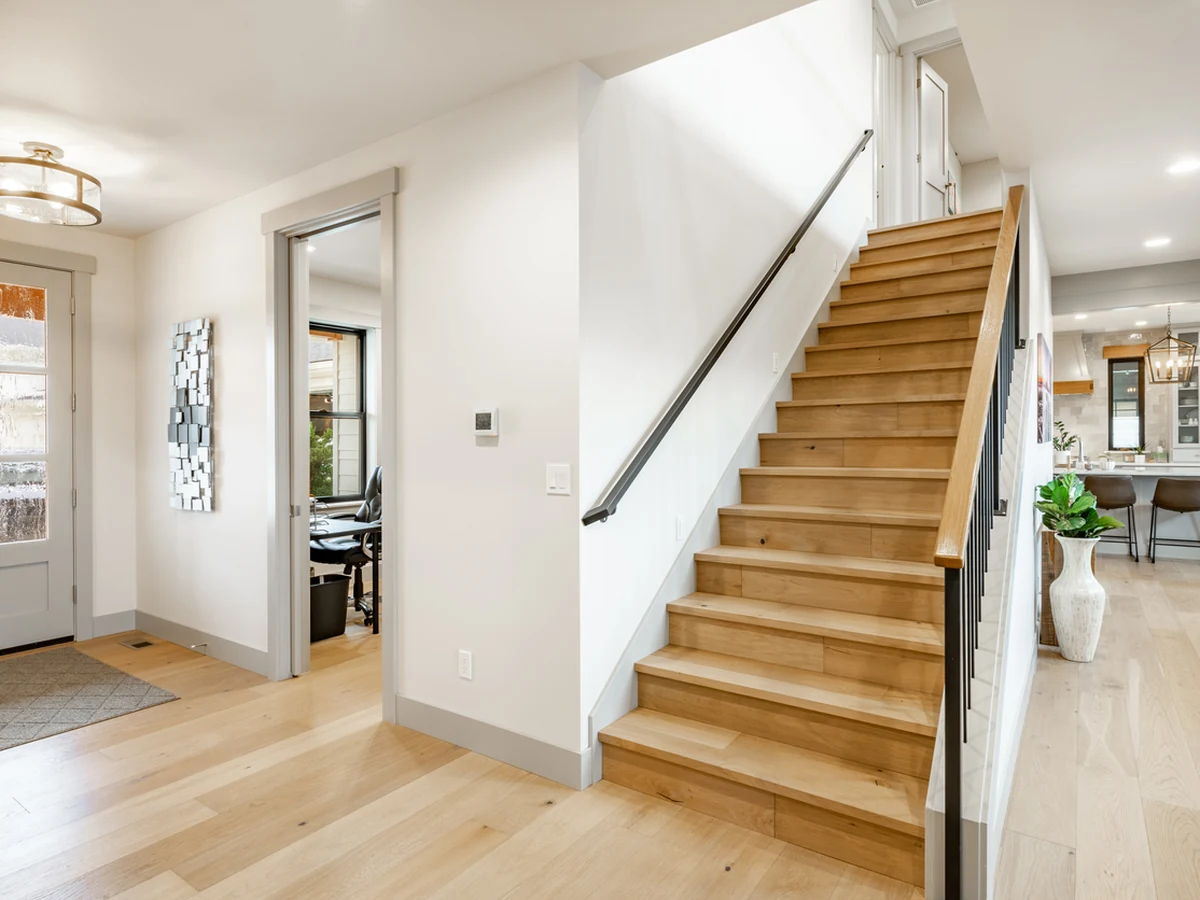 Bright farmhouse hallway with painted staircase by Darlington Decorators